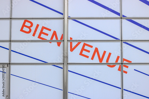 Bienvenue welcome sign on glass facade at modern airport terminal