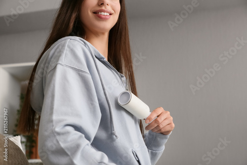 Young woman using a lint ro...
