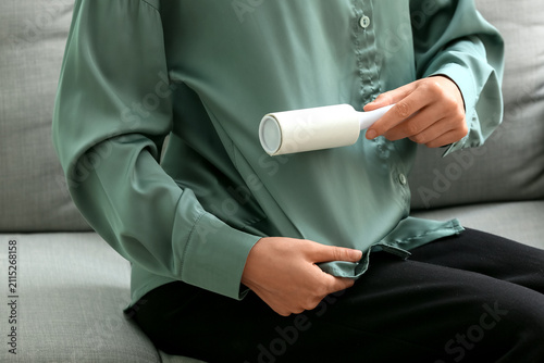 Woman using a lint roller o...