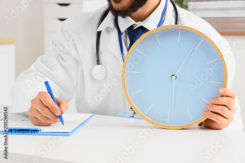 Doctor in white coat holdin...