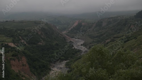 A mountain landscape with a beautiful mountain stream and a forest in the fog