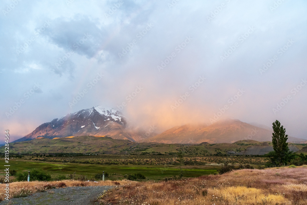 Obraz premium Early morning sunrise over Torres Del Paine national park in Patagonia, Chile, highlighting dramatic colours and a rainbow.