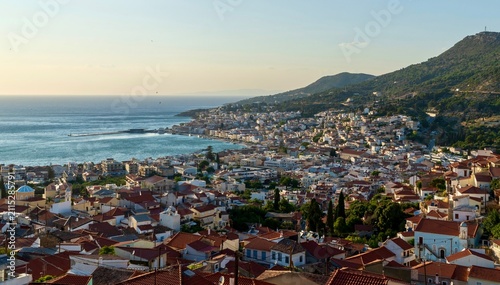 Quadro su tela Vathy, Greece - July 25, 2026: Panoramic view of Vathy from a hill on Samos Island, Greece, showing the coastal town, harbor bay, hillside houses, blue Aegean Sea water, and scenic island landscape