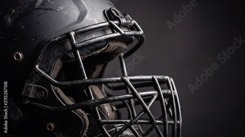 Close-Up of Worn Football Helmet Facemask Against Dark Background