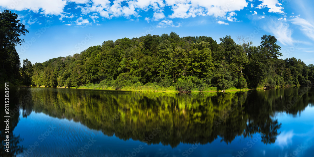 Fototapeta premium Middlebury Hiking Series: Otter Creek panorama with forest and water reflection along TAM, Trail Around Middlebury, in Vermont, USA