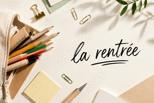 Minimal flat lay of school supplies with French back to school lettering and generous copy space for educational and seasonal designs