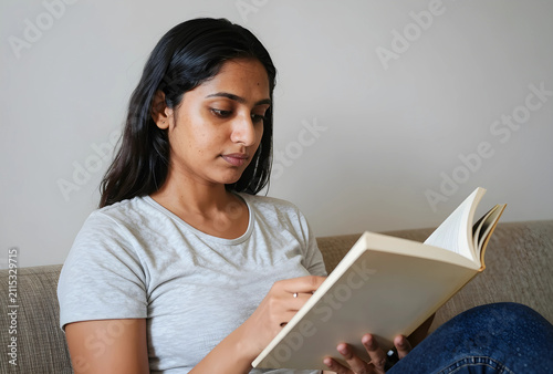 Young indian woman reading ...