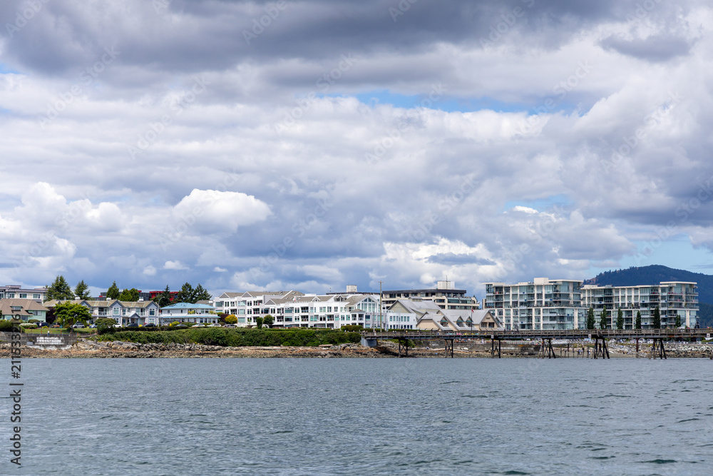 Obraz premium Cloudy Waterfront Skyline in Sidney, Vancouver Island, BC, Canada With Residential Buildings and Pier