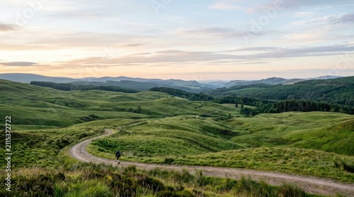 Dirt path winding through rolling green mountain hills.