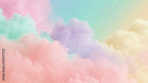 A beautiful dreamy background featuring soft fluffy clouds in pastel colors like pink and blue floating in the bright sky for a creative design project