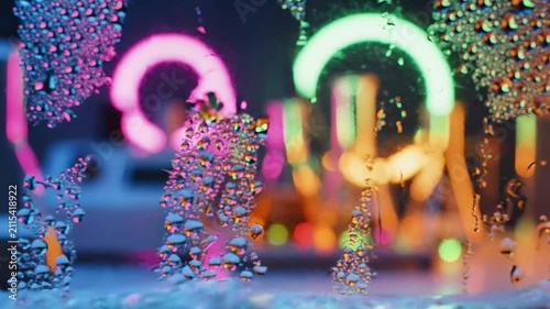 Water droplets on window with colorful neon bokeh background