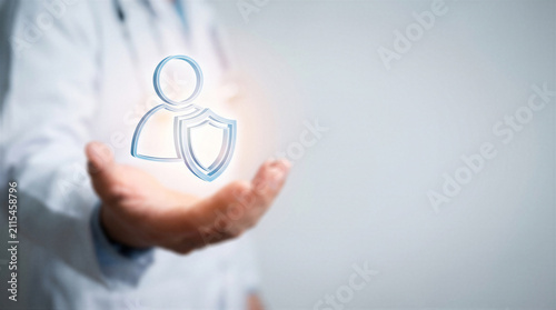 Doctor holding a digital icon of a person with a shield, representing patient privacy, data protection, and healthcare security