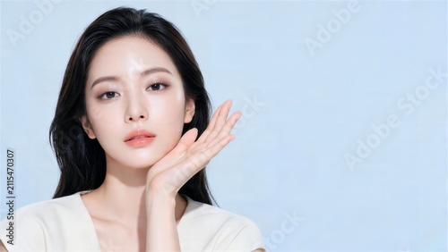 頬の横に手を添えるロングヘアの日本人女性美容モデル