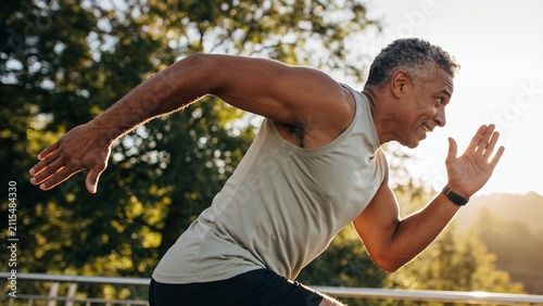 Mature man running outdoors. Active middle aged male athlete training for fitness.