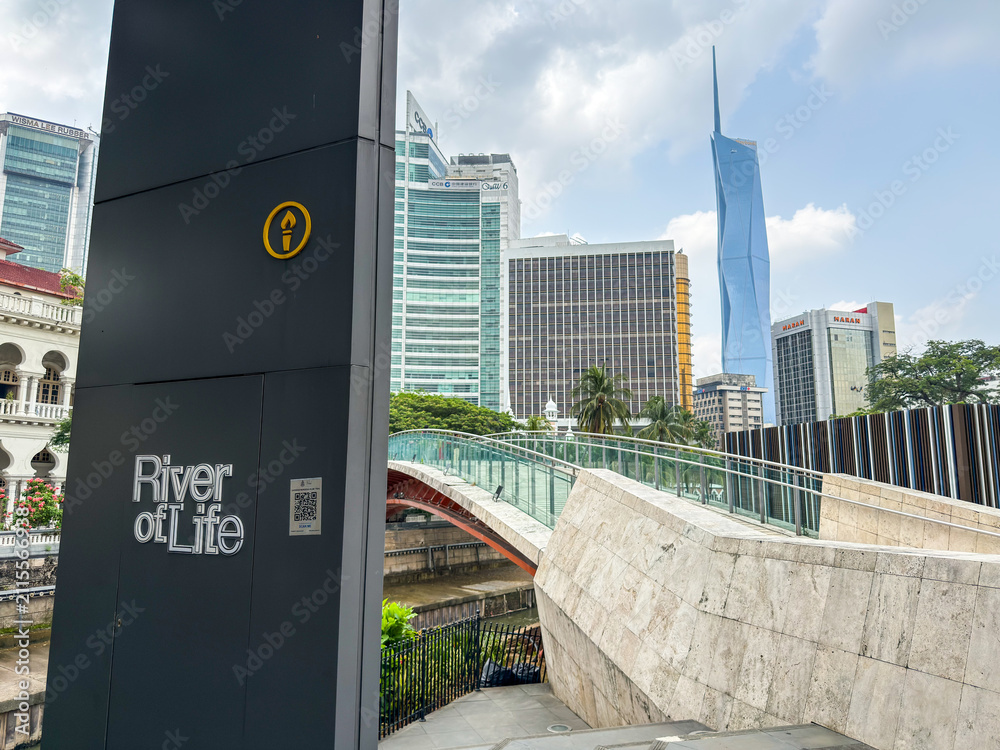 Fototapeta premium Kuala Lumpur, Malaysia - April 14, 2026: River of Life Sign Post with Merdeka 118 Tower and Pedestrian Bridge