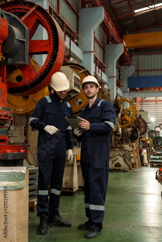 A team of engineers and staff are inspecting the production line system at a metal sheet and roofing factory. (PHOTO)	