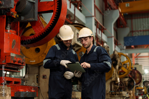 A team of engineers and staff are inspecting the production line system at a metal sheet and roofing factory. (PHOTO)	