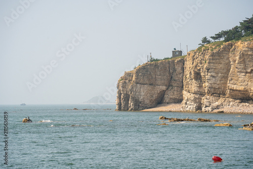 Foto Coastal Cliff and Sea Landscape with Rocky Shore