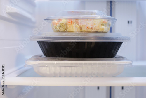 Plastic round box with food in refrigerator, concept of food delivery and storage.