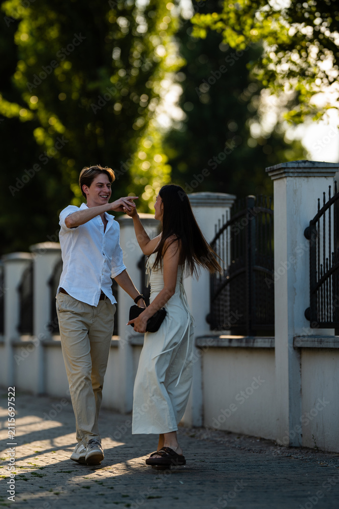 Fototapeta premium Young couple dancing laughing having fun together