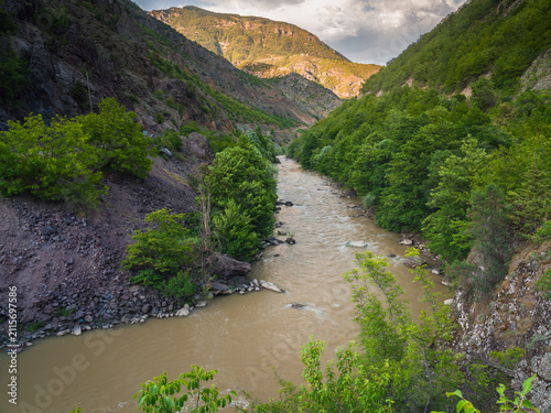 Murky river waters flowing from the mountains and nature in spring.