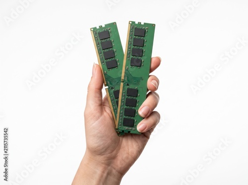 RAM Modules in Hand: A close-up shot shows a person's hand holding two green RAM modules, illustrating computer memory and data storage components.