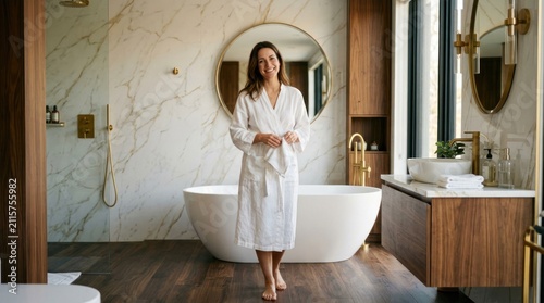 Woman in White Robe Enjoys Luxurious Modern Bathroom with Freestanding Tub.