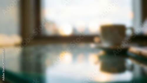 Blurred modern office glass desk with coffee cup for fintech website