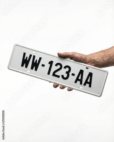 Hand Holding a French Temporary WW License Plate on White
