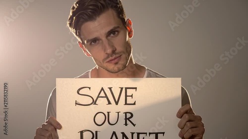 Young Man Holding 'SAVE OUR PLANET' Sign Advocating for Environmental Protection and Climate Change Awareness