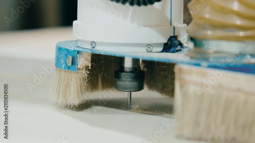 Close up of CNC machine carving wood with precision using a rotating drill bit in a workshop