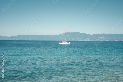 Boat sailing on the blue Adriatic Sea in Rijeka with Opatija in the background, Croatia