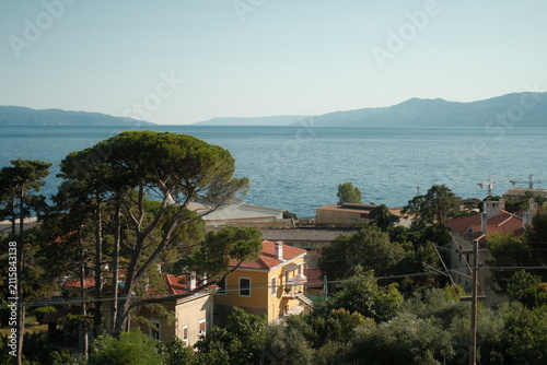 Scenic view of Rijeka coastline with blue sea, green trees and traditional house