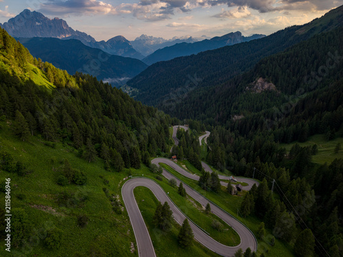 Bild auf Leinwand Winding mountain road through alpine forest scenic travel adventure