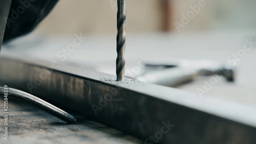 Close up of a drill bit creating a precise hole in metal during industrial drilling process