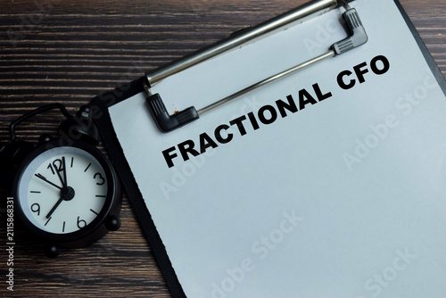 Concept of fractional CFO write on clipboard isolated on Wooden Table. For startup small business and strategic finance management