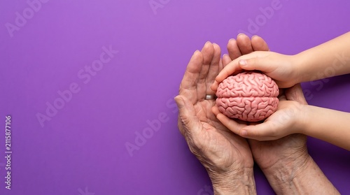 World Alzheimers Day Concept with Child and Elderly Hands Holding Brain