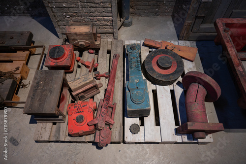 High angle view of vintage wooden foundry patterns used for making machine component molds placed on wooden pallets.