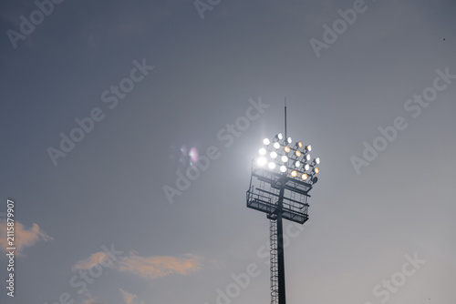 Football stadium floodlights shining at night, soccer match atmosphere and sports stadium illumination concept
