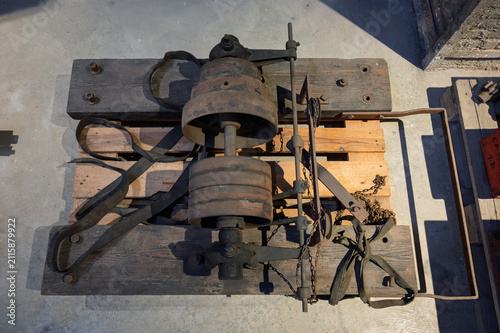 Overhead view of a vintage industrial belt drive power transmission system with iron pulleys, leather belts, and wooden frame on a pallet.