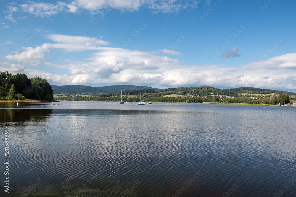 Fototapeta premium Panoramic view across Lake Lipno with calm water and blue summer sky in South Bohemia, Czech Republic