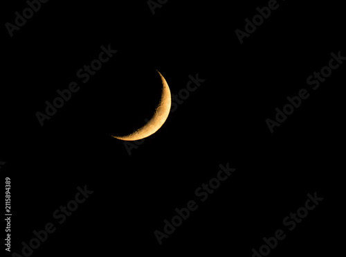Waxing Crescent moon glowing against pitch black sky at night
