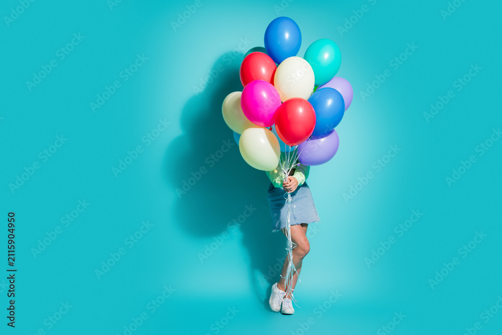 Obraz premium Young woman holding a bunch of colorful balloons against a bright turquoise background for party, celebration and joyful lifestyle concept