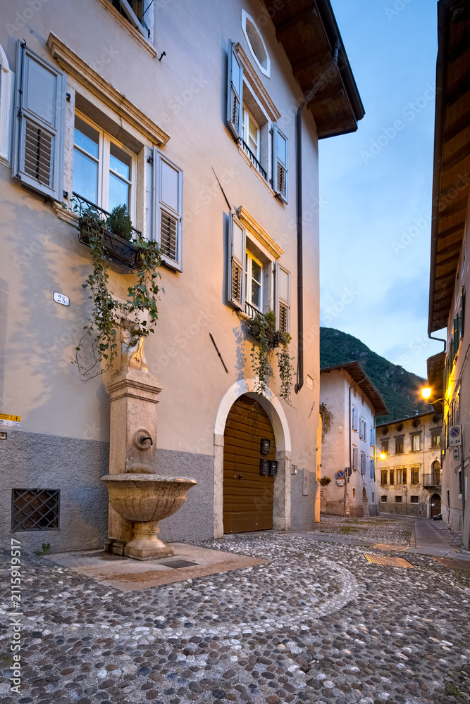 Naklejka premium Ala: Piazzetta del Mandolin, with its fountain set amongst the old houses. Trentino, Italy.
