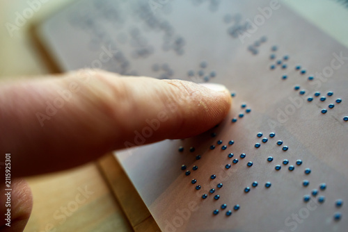 Konstfotografi Person reads raised Braille characters by touch, moving a fingertip across a page, close up view