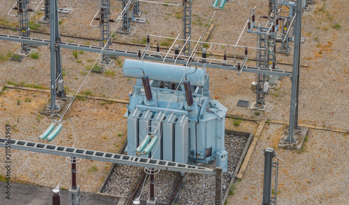 Aerial view of a high-voltage electrical transformer and switching equipment inside a modern power substation in Valence, Auvergne-Rhone-Alpes, France.