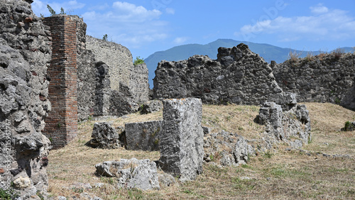 Various Ruined Structures in Ancient Pompeii on Clear Day with Mount Vesuvius in the Distance