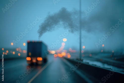 Soft-focused truck exhaust plume on a highway at dusk