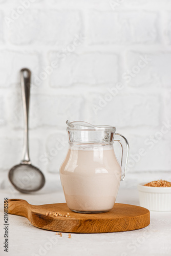 Plant based buckwheat milk alternative made from green buckwheat, dairy free healthy drink. Vertical orientation.