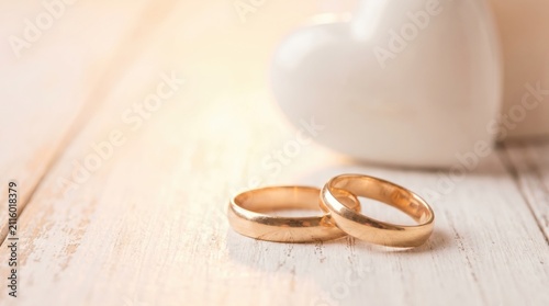 Two Gold Wedding Bands for Vow Renewal Ceremony on White Wood Table with Heart